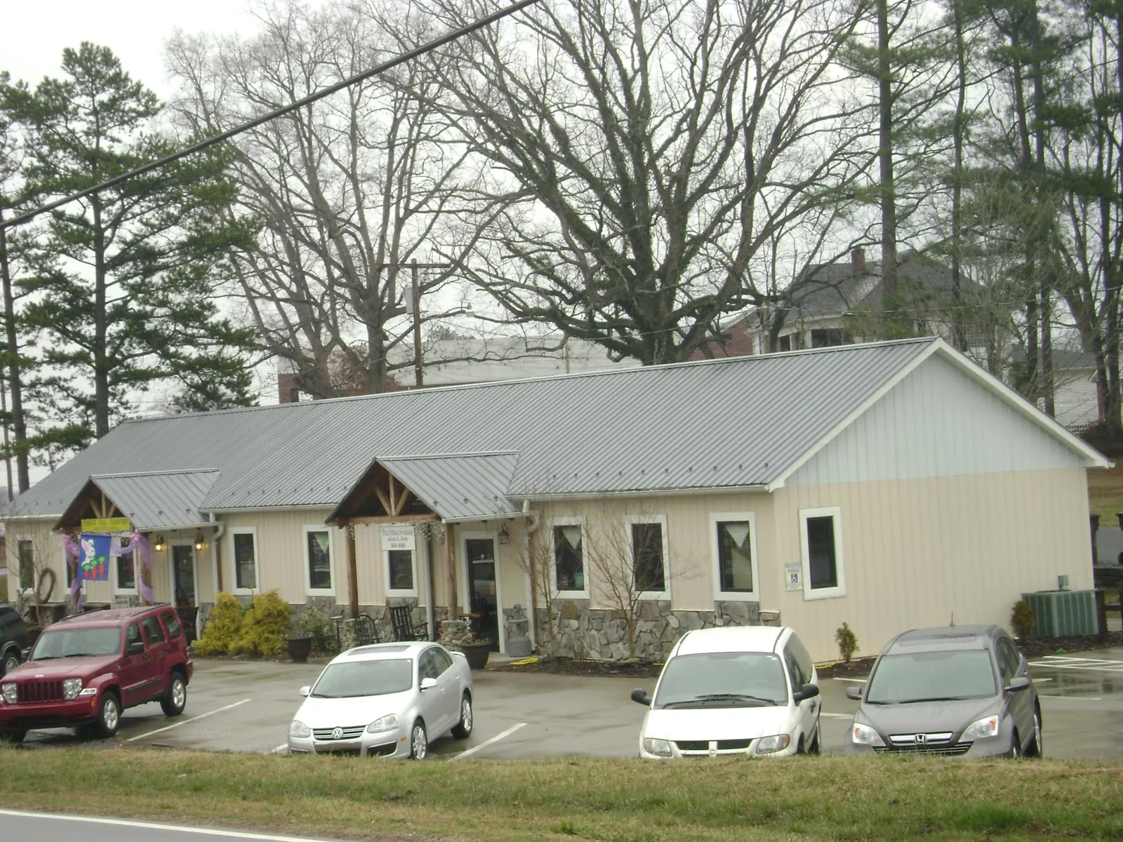 Gray metal roof with timber entry brackets on a small commercial building in Pleasant Grove